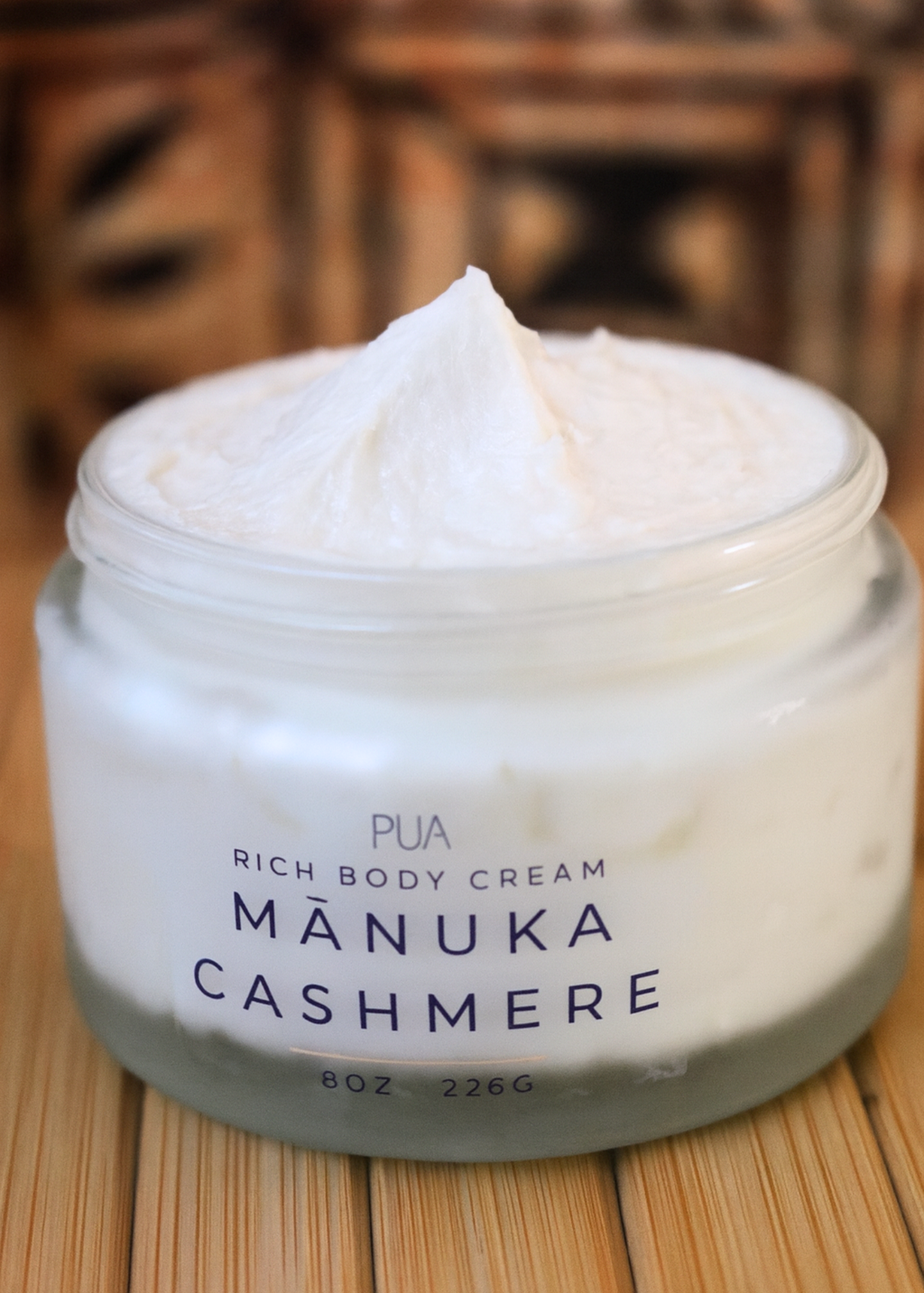 Jar of Manuka Cashmere body cream on a wooden surface